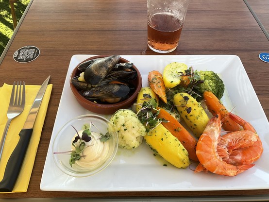 Teller mit Muscheln, Blumenkohl, Möhren, Kartoffeln, Riesennapf Aioli, Garnelen, unten drunter Kabeljau
