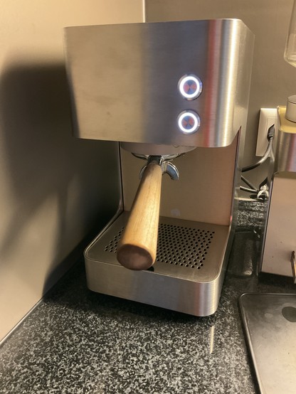 Photo of the Zuriga, a small espresso machine made from stainless steel, with two buttons on the front.