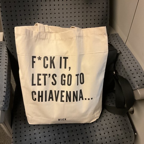 grosse weisse Stofftasche auf Bahnsitz mit Aufdruck
F*CK IT,
LET'S GO TO
CHIAVENNA...