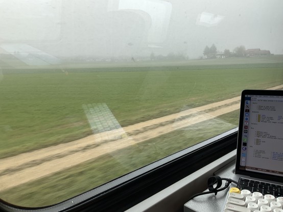 Blick aus dem zugfenster auf eine neblige landschaft.
