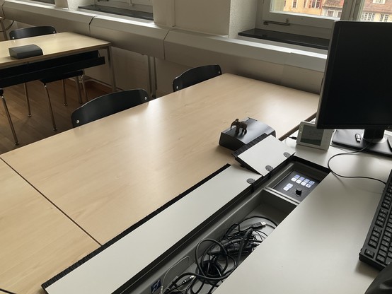 small elephant on the teacher's desk, the compartment for cables and power is open