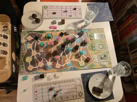 Halbes Spielfeld mit Häusern. dazu zwei Tellerchen  mit je zwei Dominosteinen