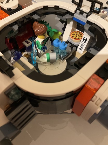 Close-up of last section with a minifig about to take a pizza out of the replicator.
